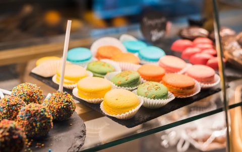 chocolate-cake-pops-with-colorful-sprinkles-macaroons-display-cabinet_23-2148028046