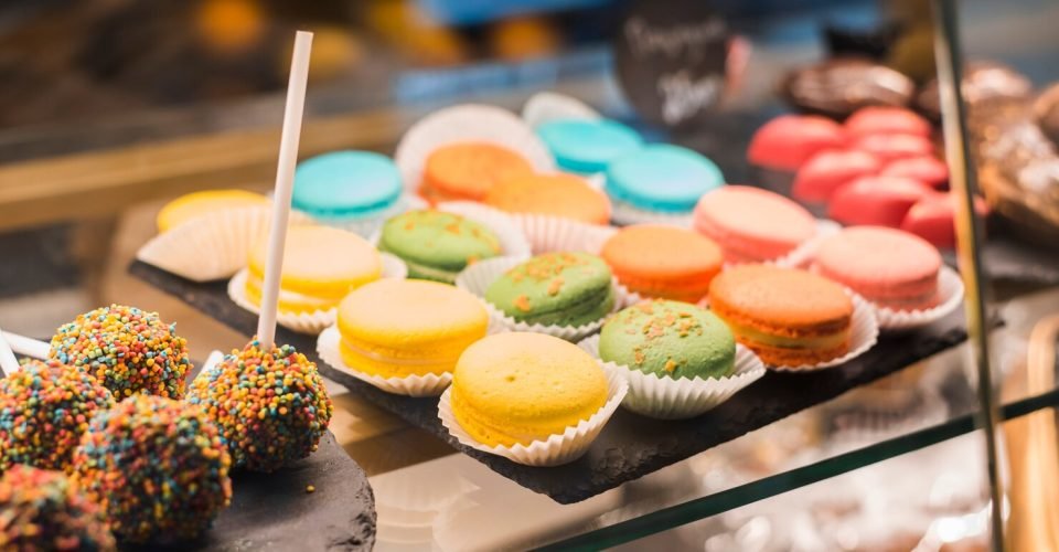 chocolate-cake-pops-with-colorful-sprinkles-macaroons-display-cabinet_23-2148028046